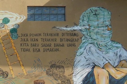 Dieses Mural in Yogyakarta schufen die Künstler Bayu Widodo und Rolly Love Hate Love 2014 während des Climate Art Festivals in Yogyakarta. Es zeigt die indonesische Version des bekannten Gedichts: „Erst wenn der letzte Baum gefällt, der letzte Fisch gefangen ist, werden wir begreifen, dass man Geld nicht essen kann.“ © Anett Keller